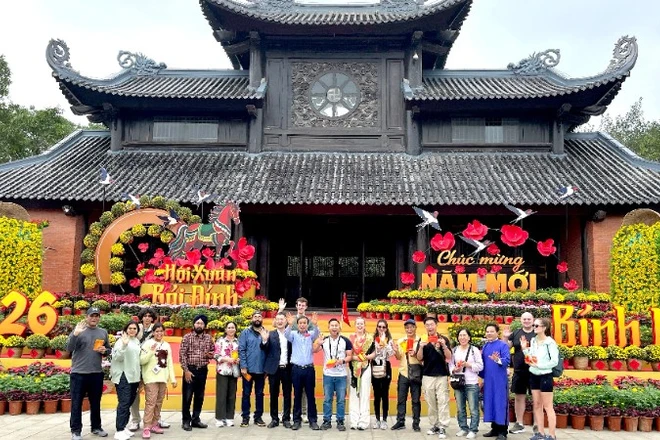 Ngành du lịch Ninh Bình cùng đại diện các đơn vị tặng hoa, chào đón những vị khách đầu tiên đến với chùa Bái Đính.