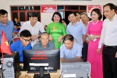 Các đại biểu và người dân tham quan, trải nghiệm thực hiện mô hình "công dân số cộng đồng" và lớp học "Bình dân học vụ số".