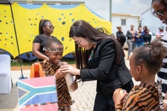 Phu nhân Lê Thị Bích Trân tặng quà cho các em học sinh khu dân cư Tsakane. (Ảnh: NGUYỄN HỒNG)