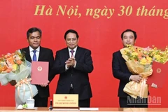 Thủ tướng Chính phủ Phạm Minh Chính trao Quyết định bổ nhiệm và tặng hoa chúc mừng hai đồng chí Trần Đức Thắng và Hồ Văn Niên. (Ảnh: TRẦN HẢI)