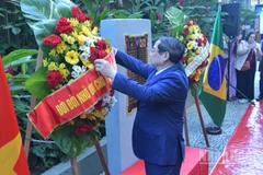 Thủ tướng Chính phủ Phạm Minh Chính chỉnh hoa chuẩn bị thực hiện nghi thức dâng hoa tưởng niệm Chủ tịch Hồ Chí Minh tại Rio de Janeiro (Ảnh: Thanh Giang).
