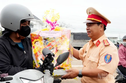 Đội Cảnh sát giao thông đường bộ số 3, Phòng Cảnh sát giao thông Công an tỉnh Lâm Đồng trao quà tặng người dân trên hành trình về quê đón Tết. 