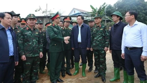 Chủ tịch Ủy ban nhân dân tỉnh Phú Thọ Trần Duy Đông (áo đen, đứng giữa) trao đổi với các đơn vị quân đội về phương án lắp cầu phao qua sông Lô.