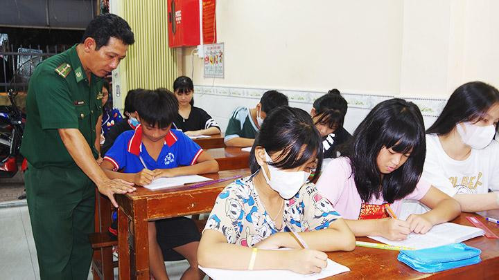 Thiếu tá Nguyễn Văn Tưởng hướng dẫn các bạn nhỏ làm bài.