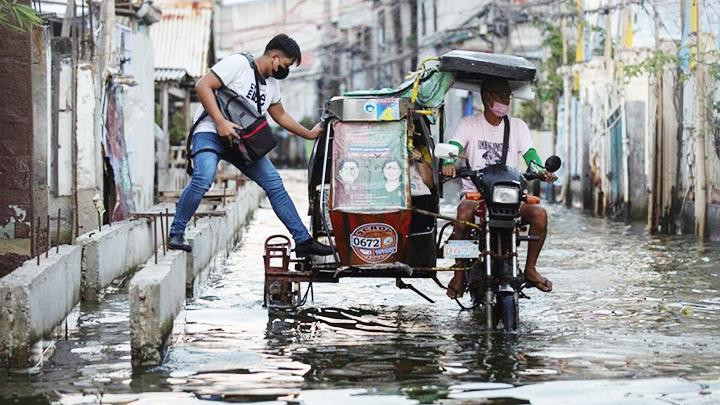 Xe ôm cải tiến vượt lũ lụt. Ảnh: AP