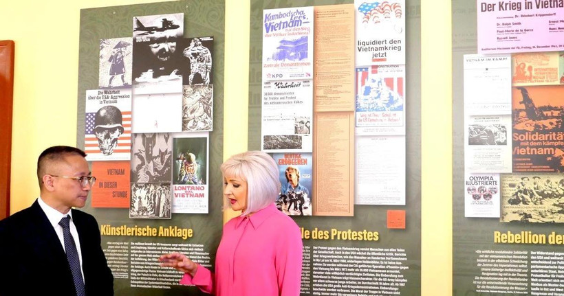 Bà Claudia Opitz, một trong ba người tổ chức "VIETNAM 75" giới thiệu với Tham tán Công sứ Chu Tuấn Đức về triển lãm. (Ảnh: TTXVN)