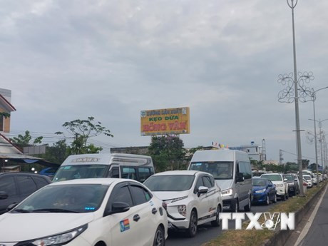 Xe ôtô nối đuôi nhau, nhích từng chút một qua cầu Rạch Miễu. (Ảnh: TTXVN)
