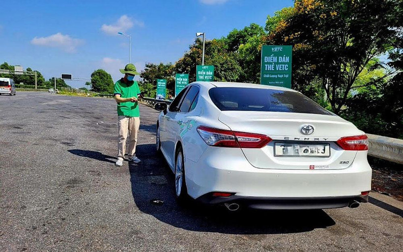 Nhân viên VETC hướng dẫn khách hàng dán thẻ ETC và nạp tiền vào tài khoản.