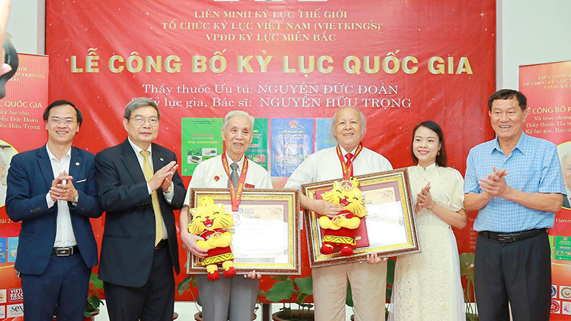 Thầy thuốc Ưu tú Nguyễn Đức Đoàn (thứ ba từ trái sang) và bác sĩ Nguyễn Hữu Trọng (thứ tư từ trái sang) nhận chứng nhận từ đại diện Tổ chức kỷ lục Việt Nam.
