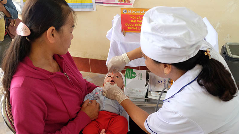 Cán bộ Trạm Y tế xã Đồng Sơn, Hoành Bồ (Quảng Ninh) cho trẻ uống vắc-xin phòng bệnh.