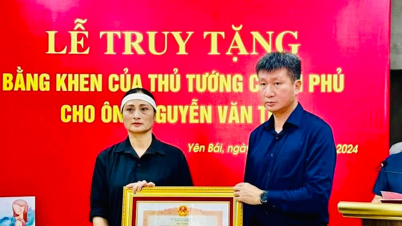 Chủ tịch Ủy ban nhân dân tỉnh Yên Bái Trần Huy Tuấn trao Bằng khen của Thủ tướng Chính phủ cho gia đình anh Nguyễn Văn Thi. (Ảnh: THANH SƠN)