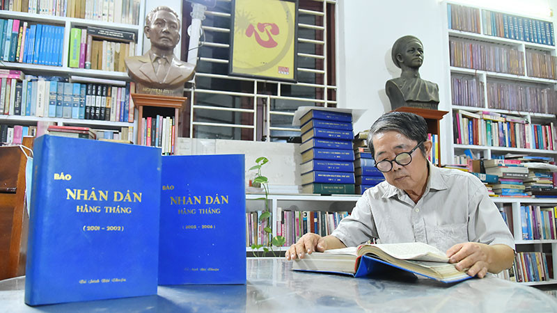 Nhà báo Mai Sông Bé với các số báo Nhân Dân hằng tháng mà ông đã dày công sưu tầm và đóng thành quyển để lưu giữ.