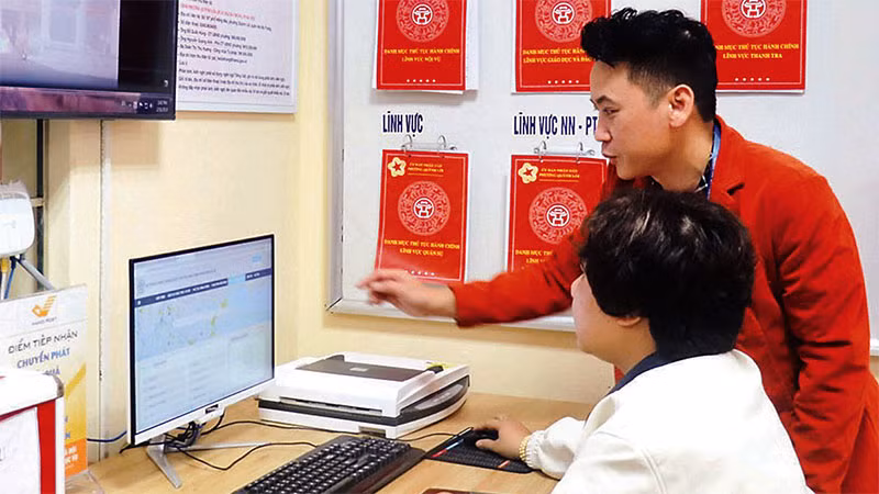 Cán bộ phường Quỳnh Lôi (quận Hai Bà Trưng) hướng dẫn người dân thực hiện dịch vụ công trực tuyến. (Ảnh: LINH NGUYỄN )