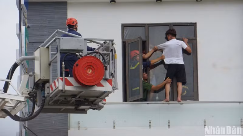 Lực lượng chức năng tiếp cận, ngăn kịp thời nam thanh niên trèo ra lan can tầng 4 của một nhà nghỉ, nghi có ý định tự tử. (Ảnh: ANH ĐÀO)