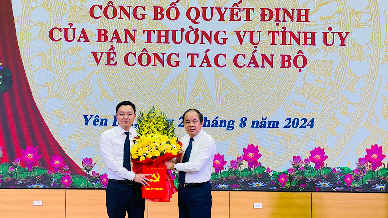 Đồng chí Tạ Văn Long, Phó Bí thư Thường trực Tỉnh ủy tặng hoa Chánh Văn phòng Tỉnh ủy An Hoàng Linh. (Ảnh: THANH SƠN)