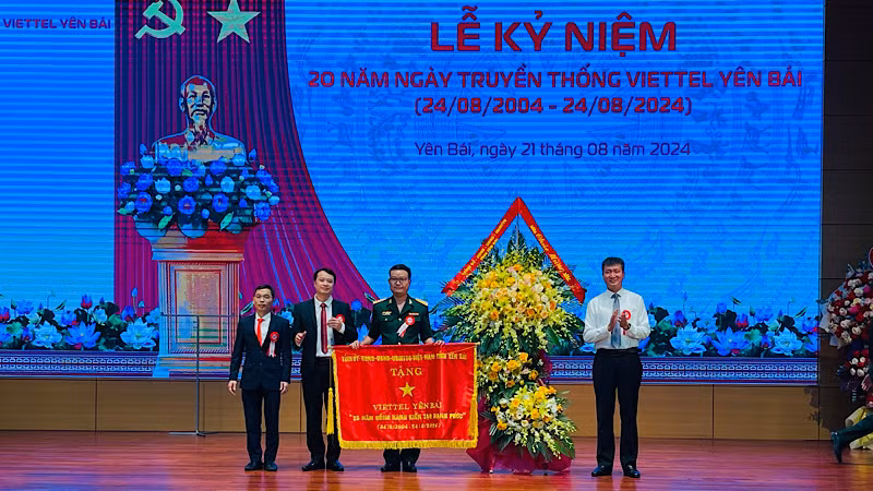 Chủ tịch Ủy ban nhân dân tỉnh Trần Huy Tuấn trao cờ thêu cho đơn vị. (Ảnh: THANH SƠN)