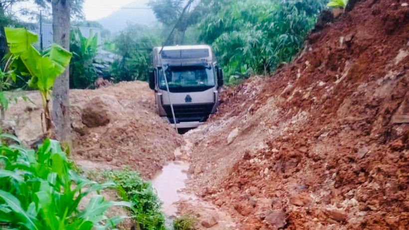 Xe đầu kéo bị đất đá vùi lấp tại đường tỉnh 164. (Ảnh: THANH SƠN)