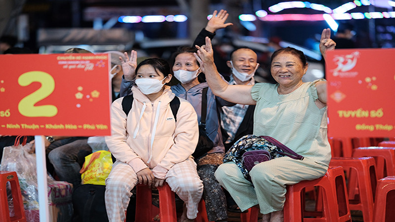Người dân vui mừng trước khi lên “Chuyến xe hạnh phúc” để về quê đón Tết.