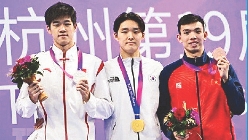 Nguyễn Huy Hoàng (áo đỏ) đoạt HCĐ bơi 400m tự do nam. (Ảnh AFP/TTXVN)