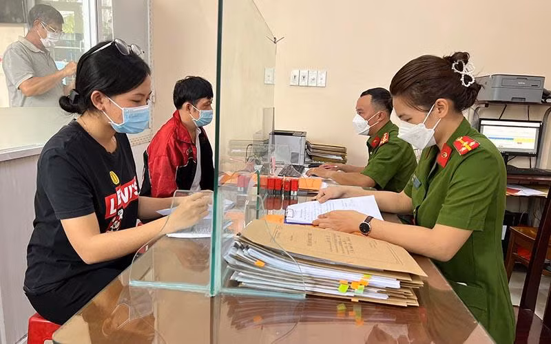 Cán bộ Công an phường Tân Chánh Hiệp, Quận 12, Thành phố Hồ Chí Minh hướng dẫn người dân thực hiện thủ tục hành chính. (Ảnh QUANG QUÝ)