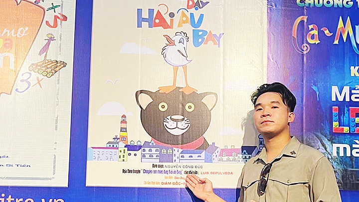 Tác giả Nguyễn Công Đức bên poster vở kịch.