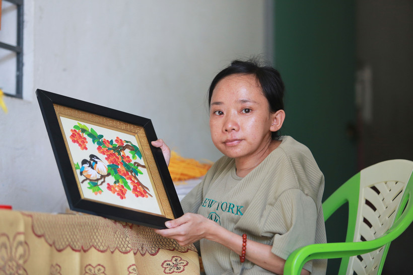 Chị Láng bên một tác phẩm tranh giấy xoắn.