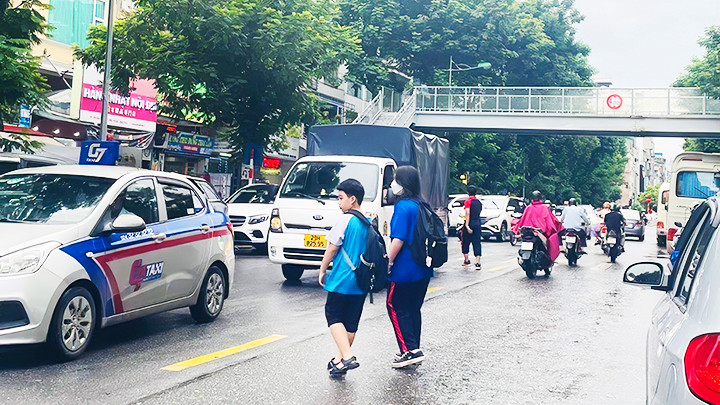Nhiều người thản nhiên băng qua đường không dùng cầu bộ hành. Ảnh: PHAN QUỲNH