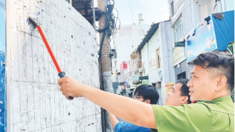 Lực lượng chức năng Quận 3 phối hợp ra quân bóc xóa quảng cáo sai quy định trên địa bàn.