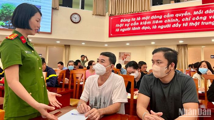 Trung tá Nguyễn Thị Hồng Thủy trao đổi cùng các chủ cơ sở trên địa bàn quận tại chương trình tập huấn.