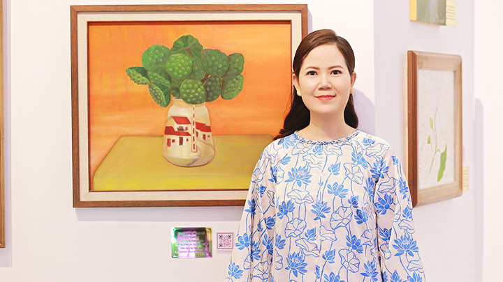 Họa sĩ Kim Đức bên một tác phẩm trong triển lãm.