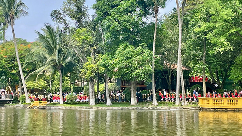 Du khách tham quan nhà sàn, ao cá Bác Hồ trong Khu Di tích Chủ tịch Hồ Chí Minh tại Phủ Chủ tịch.