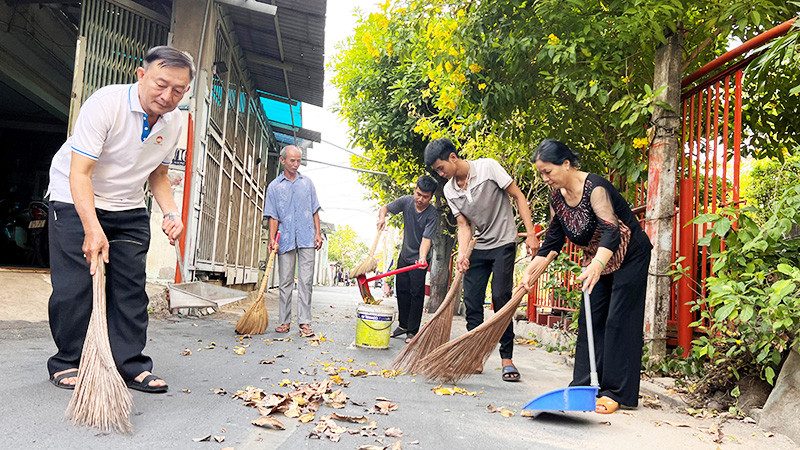 Cán bộ Mặt trận phường Trường Thọ, thành phố Thủ Đức và người dân dọn dẹp vệ sinh tuyến đường trên địa bàn.