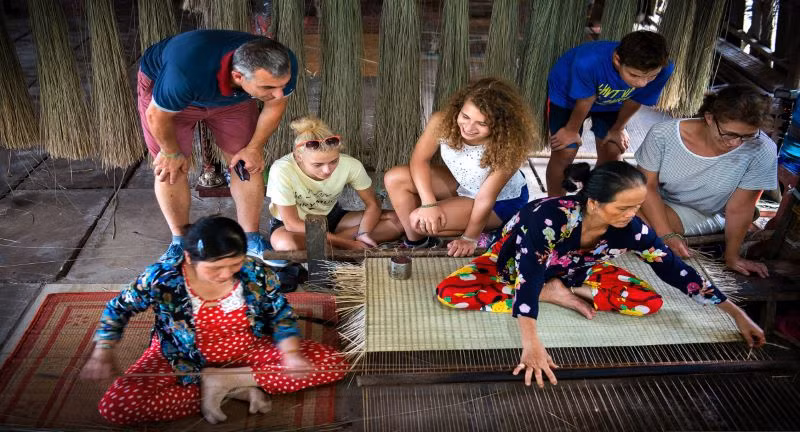 Du khách quốc tế trải nghiệm nghề làm chiếu thủ công. (Ảnh: Vietnamtravel)