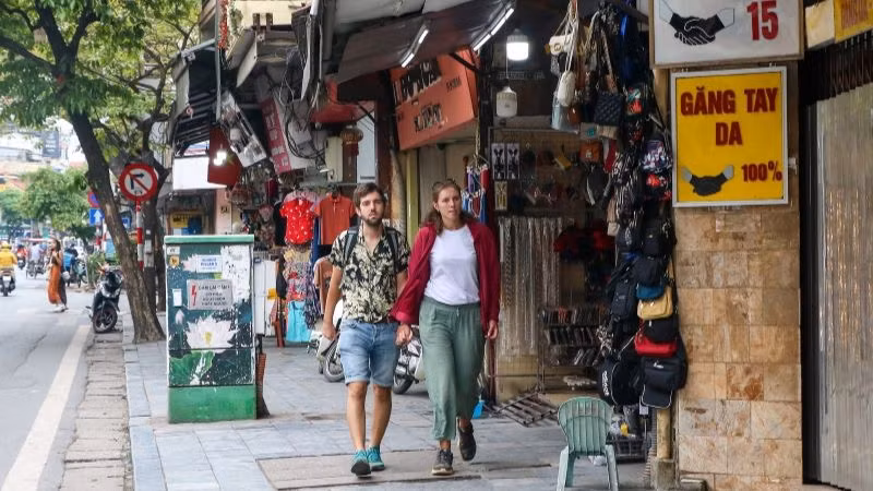 Du khách nước ngoài rảo bước trên phố Hàng Đào, Hà Nội. (Ảnh: NHẬT QUANG)