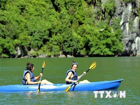 Du khách trải nghiệm chèo thuyền kayak, thuyền tay trên Vịnh Hạ Long. (Ảnh: Thanh Vân/TTXVN)