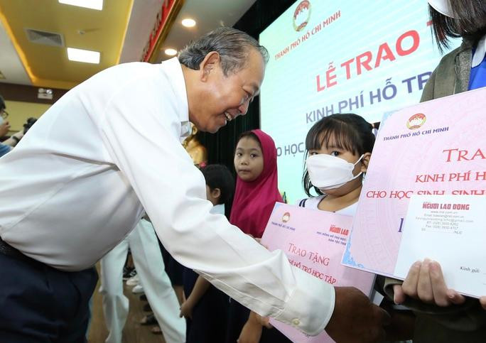 Đồng chí Trương Hoà Bình trao học bổng cho các em học sinh. (Ảnh: Hoàng Triều)
