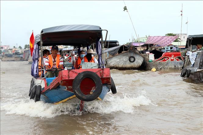 Thuyền chở du khách tham quan chợ nổi Cái Răng (Ảnh: TTXVN)