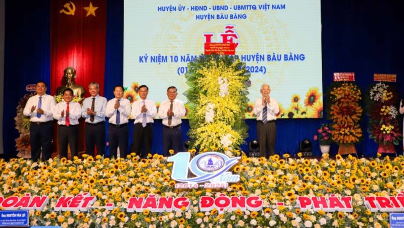 Nguyên Chủ tịch nước Nguyễn Minh Triết trao tặng lẵng hoa chúc mừng huyện Bàu Bàng. 