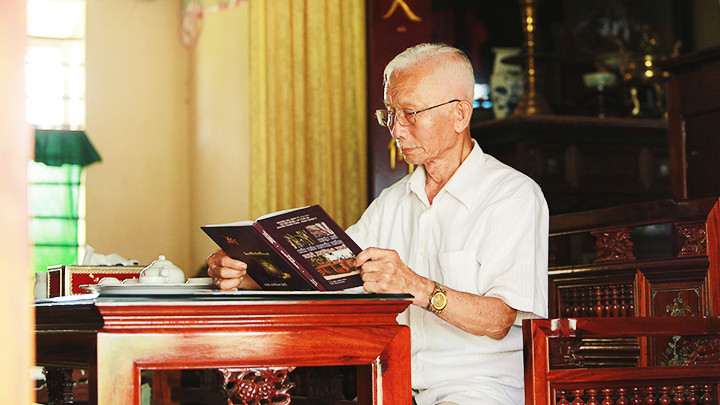 Nghệ nhân Lê Kim Tân bên bộ trường kỷ của gia đình.