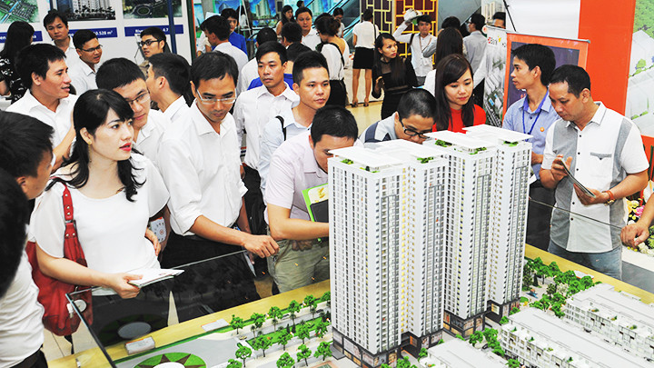Khách hàng tìm hiểu thông tin dự án chung cư tại sàn giao dịch. Ảnh: ANH NGUYỆT
