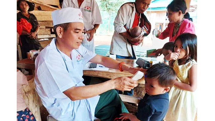 Thiếu tá quân nhân chuyên nghiệp Trần Minh Vũ, y sĩ quân y Đồn Biên phòng A Vao) khám, chữa bệnh cho bà con Pa Ling.