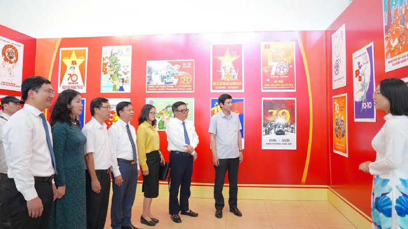 Các đại biểu nghe giới thiệu về ý nghĩa của những bức tranh cổ động chào mừng 70 năm Ngày Giải phóng Thủ đô.