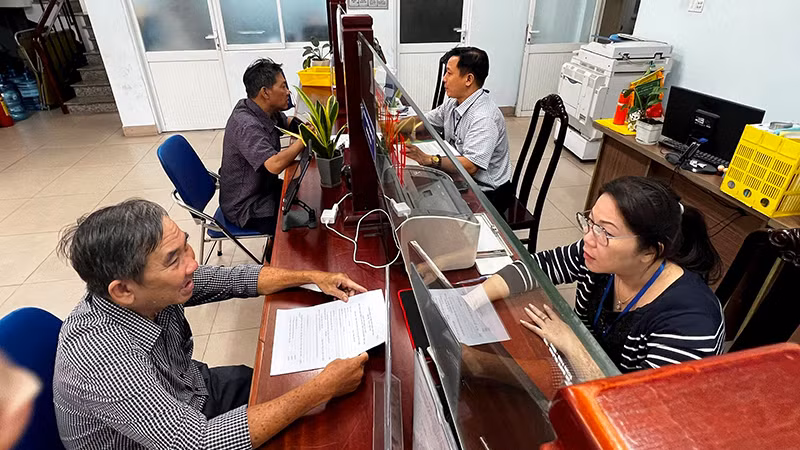 Người dân thực hiện thủ tục hành chính tại Ủy ban nhân dân Phường 6 (quận Bình Thạnh, Thành phố Hồ Chí Minh) trước thời điểm phường này sáp nhập với Phường 7. (Ảnh QUANG QUÝ)