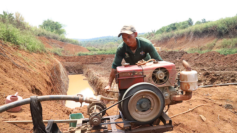 Nông dân Đắk Lắk thuê xe múc hố ngay dưới lòng hồ để tìm nước tưới cây trồng.