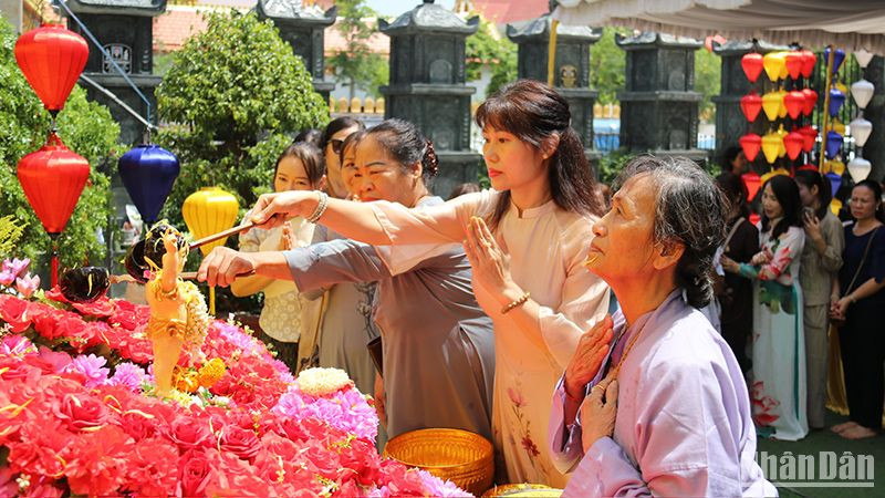 Chư tăng, phật tử cùng bà con kiều bào thực hiện nghi lễ tắm Phật. (Ảnh: Hải Tiến)