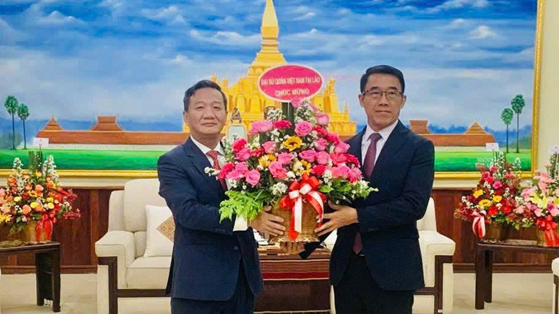 Đại sứ Nguyễn Minh Tâm chúc mừng Quyền Trưởng Ban Đối ngoại Trung ương Đảng Nhân dân Cách mạng Lào Bounlua Phandanouvong. (Ảnh: Cộng tác viên)