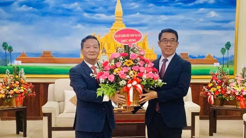 Đại sứ Nguyễn Minh Tâm chúc mừng Quyền Trưởng Ban Đối ngoại Trung ương Đảng Nhân dân Cách mạng Lào Bounlua Phandanouvong. (Ảnh: Cộng tác viên)