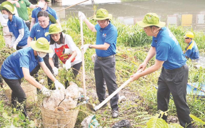 Lãnh đạo và thanh niên thành phố vớt rác bảo vệ môi trường.