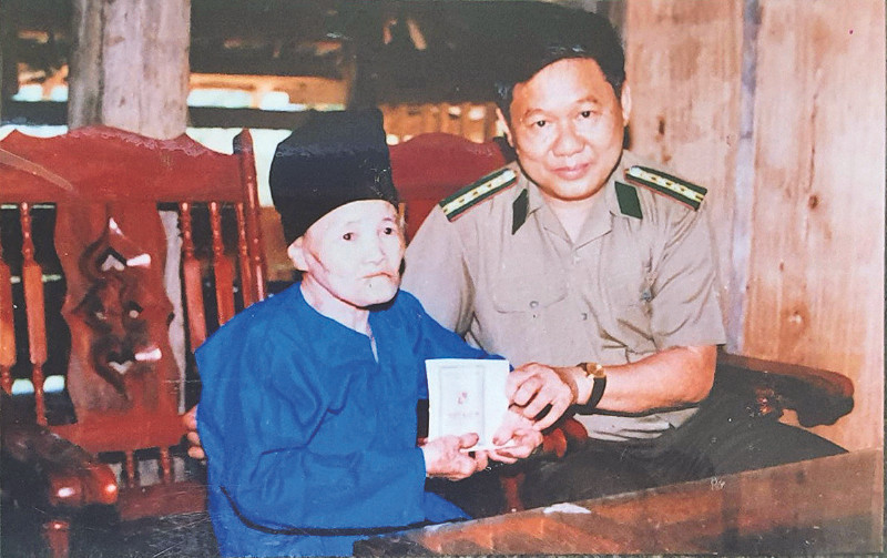 Thiếu tướng Phạm Hữu Bồng tặng sổ tiết kiệm cho bà mẹ Việt Nam anh hùng Trương Thị Hoa. 