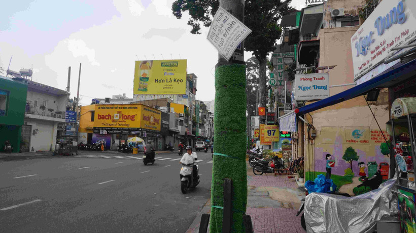 Quảng cáo rao vặt bán nhà đất dán đè lên phần cỏ nhựa gây mất mỹ quan.